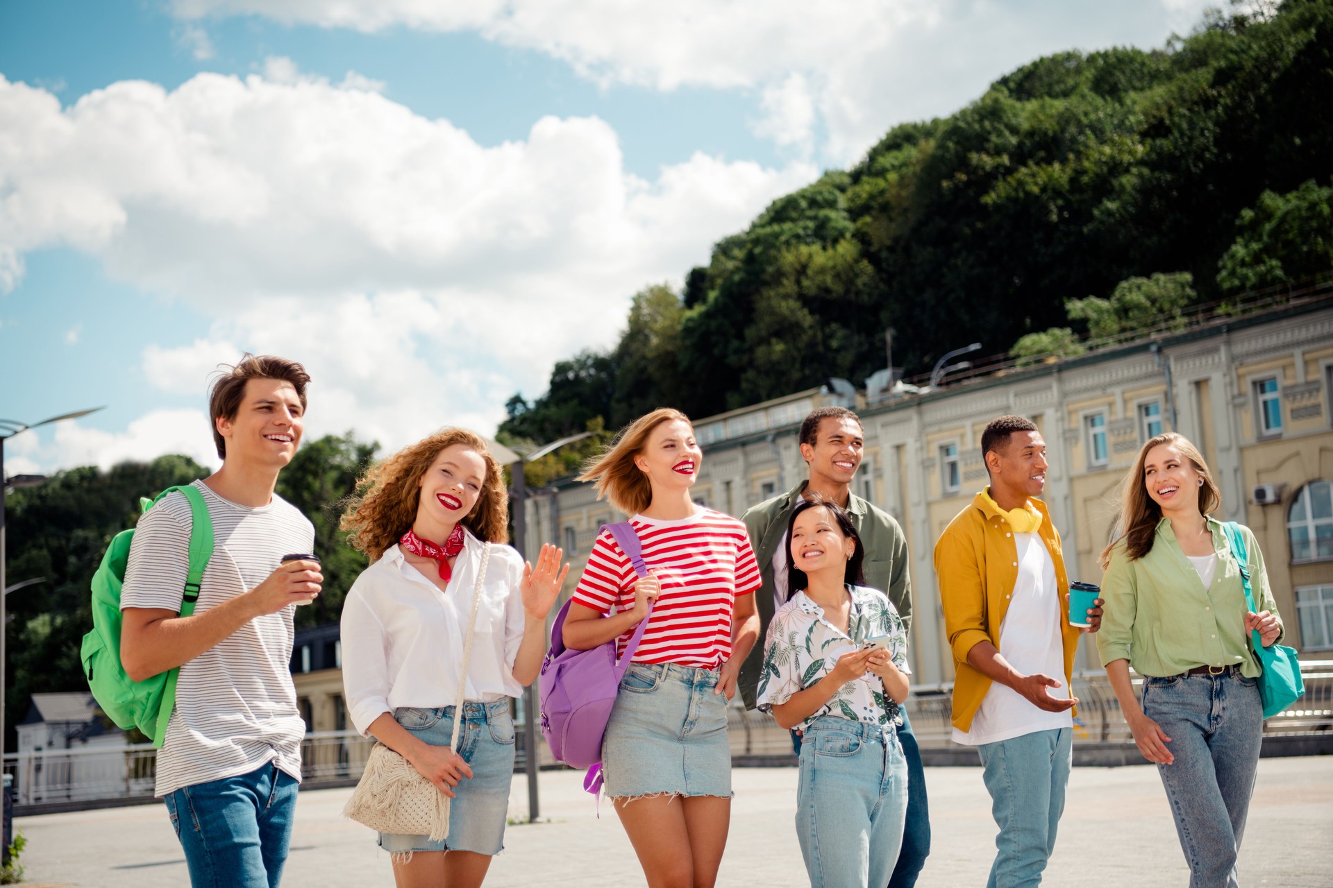 Happy young adults enjoying a casual walk together in a lively urban setting during a sunny day